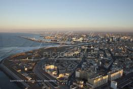 Image du Maroc Professionnelle de  Vue du minaret de la Mosquée Hassan II, cette image nous offre au premier plan à droite les constructions du quartier Cuba qui résistent encore à la pioche des démolisseurs. Juste en face à gauche un panorama sur le chantier de la future Marina. Au fond une partie du port alors qu'en haut et à droite le centre de Casablanca, Lundi 12 Janvier 2009.  (Photo / Abdeljalil Bounhar)
 